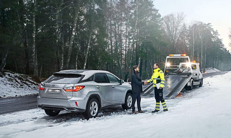 Recovery team helping a car at the roadside in winter