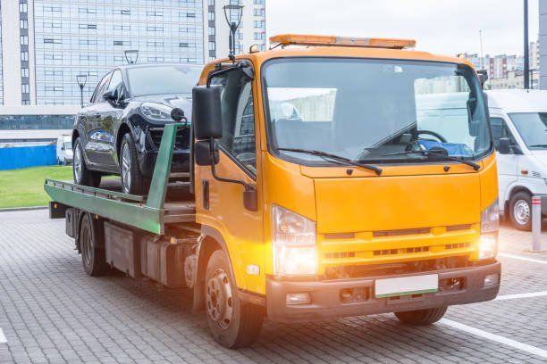 Recovery truck carrying a car through the city
